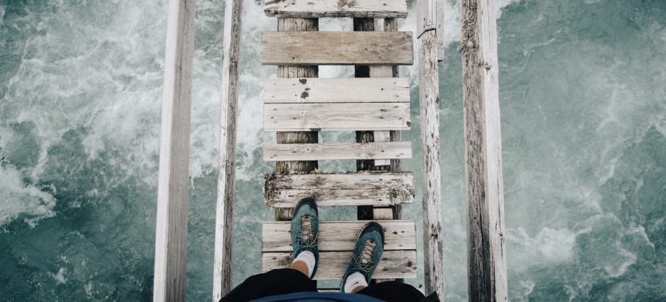 A view of two feet about to take a step of faith across a bridge